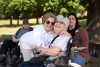 Pflegekraft und Seniorin lächeln gemeinsam im Park