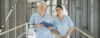 Kolleginnen laufen über den Flur mit einem Tablet