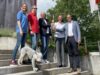Team zusammen auf Treppe mit Hund