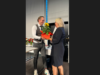 Frau Scheck bekommt Sonnenblume überreicht